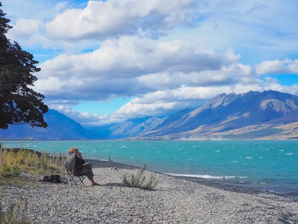 Nicky sitting in a camp chair on Lake Ohau beach