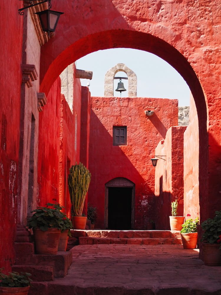 A red arch leading to a red wall