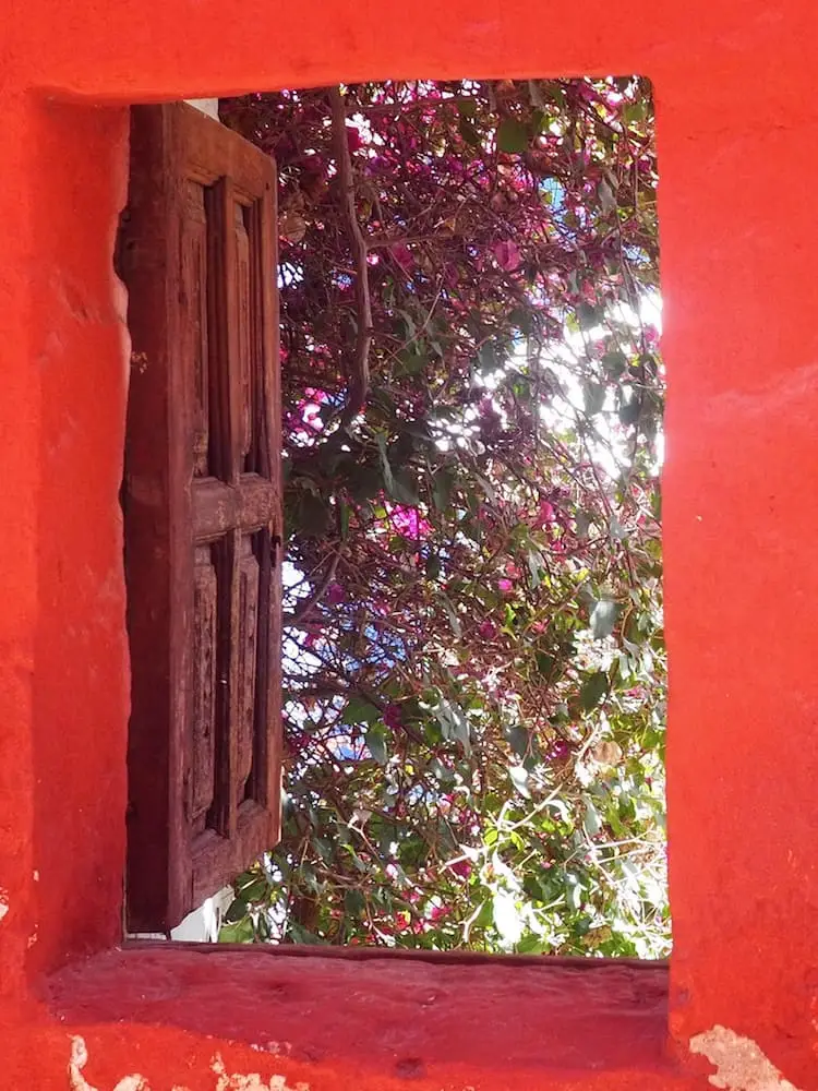 An open window on a red wall