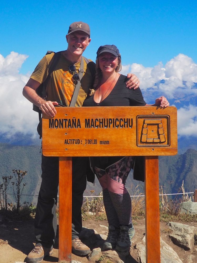 Ian and Nicky pose behind the sign at the summit of Machu Picchu Mountain