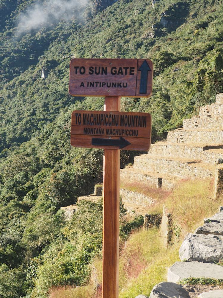 Signpost pointing to the Sun Gate and Machu Picchu Mountain