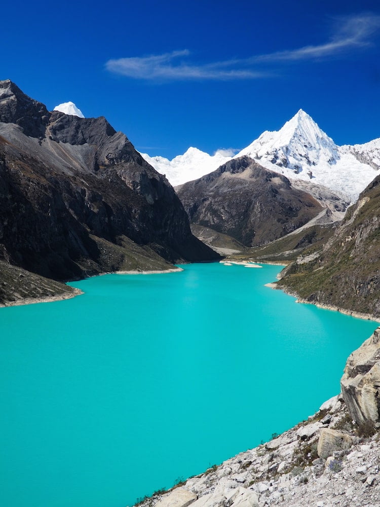 Turquoise lake in the foreground, snowy mountains in the background
