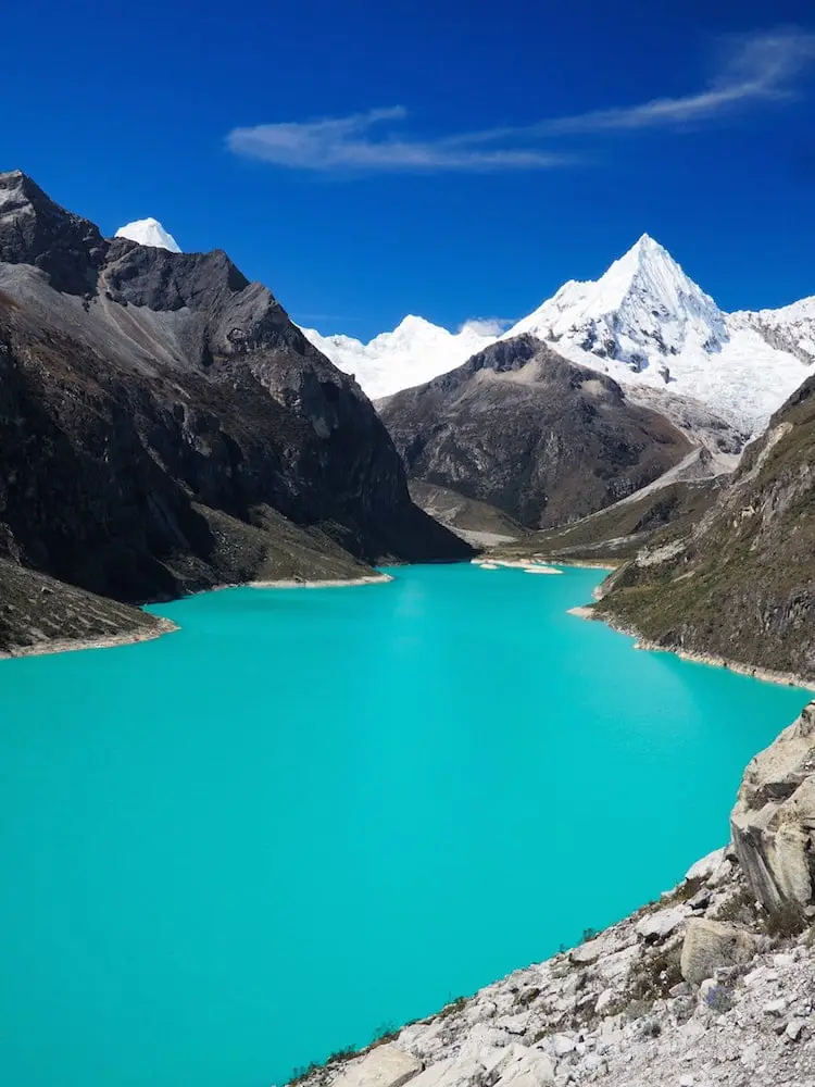 Turquoise lake in the foreground, snowy mountains in the background