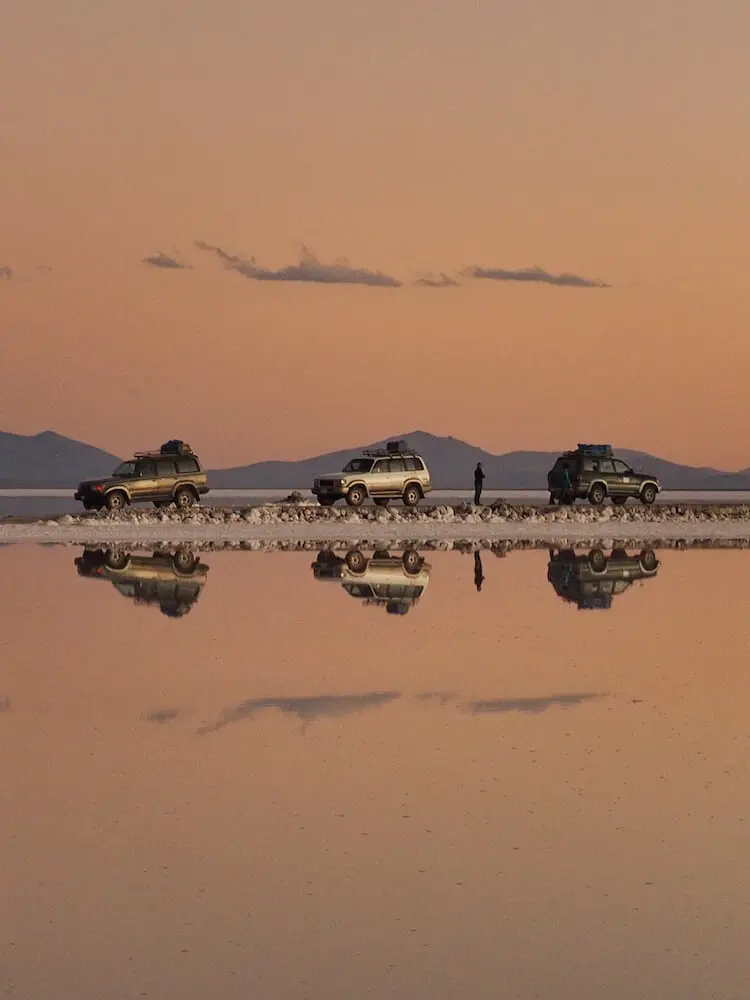 Jeeps parked at the Salar de Uyuni at sunset