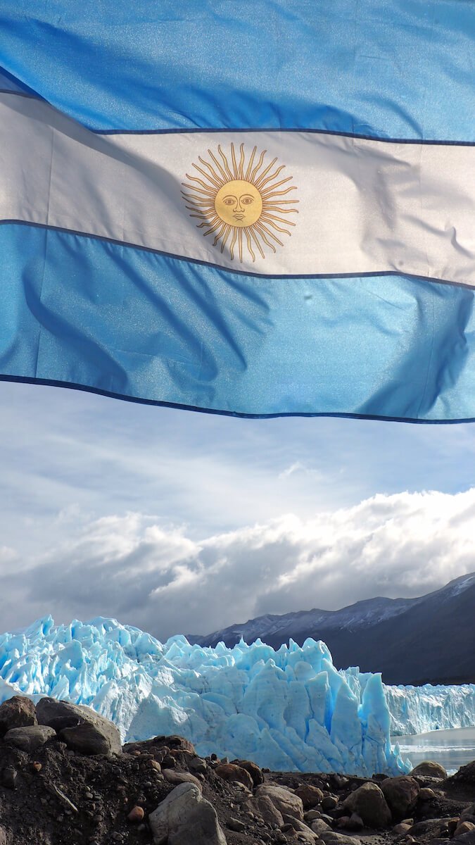The Argentinian flag with Perito Moreno Glacier in the background
