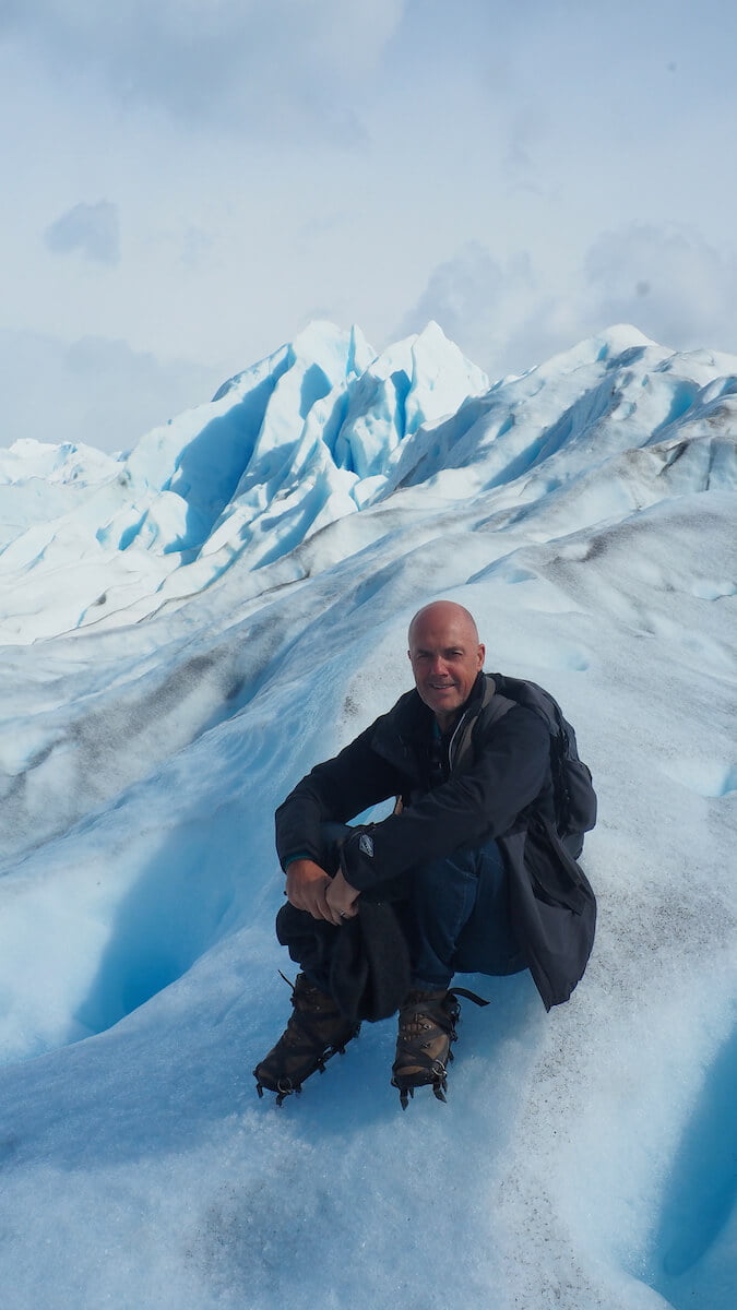 Ian sitting down on the glacier