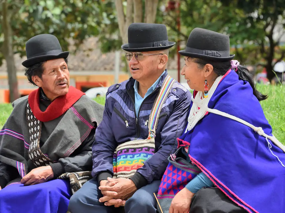 Two men and a woman chatting on a bench