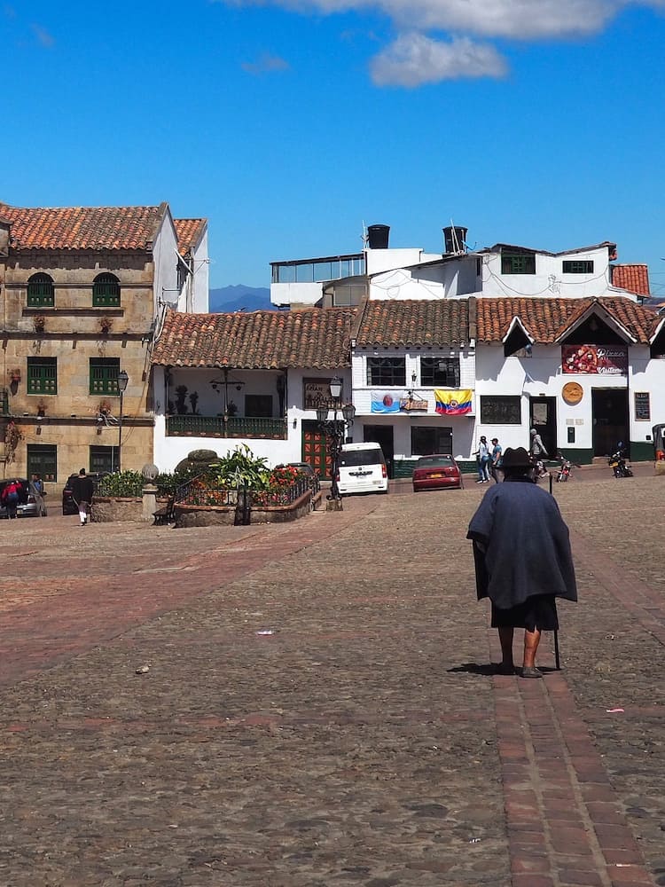An elderly lady crossing the main square