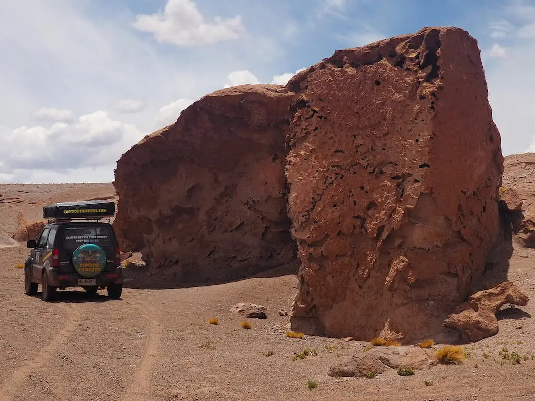 Camper van parked beside rock formation