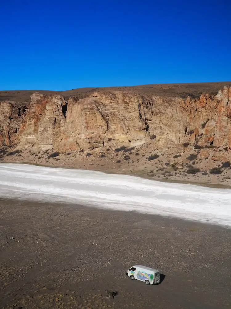 Camper van parked beside salt flats 