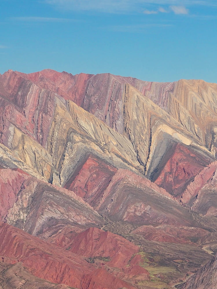 Mountainside with pink, cream and grey colourings in the shape of sharks' teeth