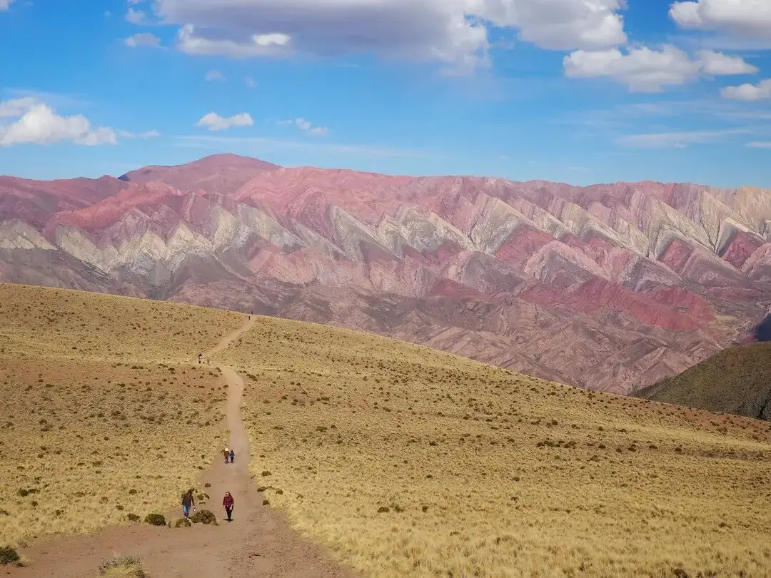 Footpath leading to a view of a mountainside with multiple colours
