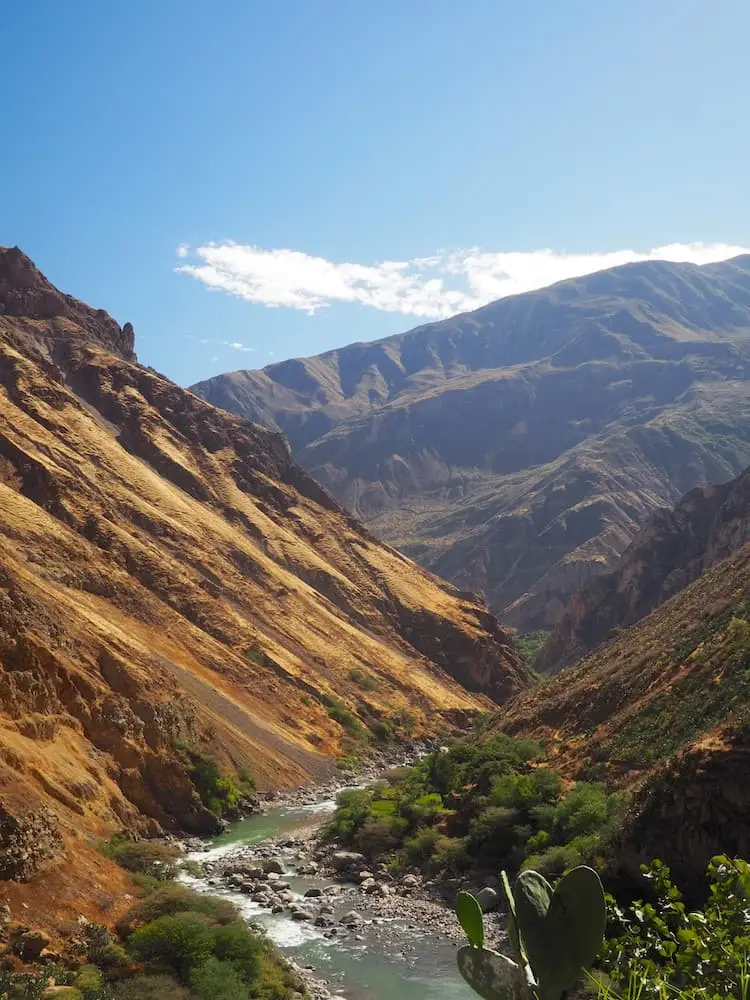 Mountains either side of a deep canyon with a river running through it
