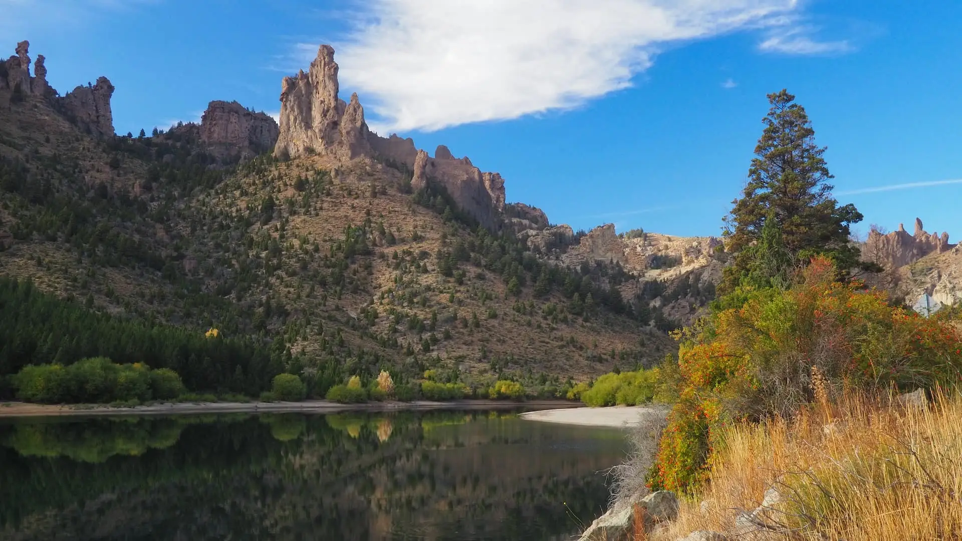 River with reflections in the water and craggy mountains above it