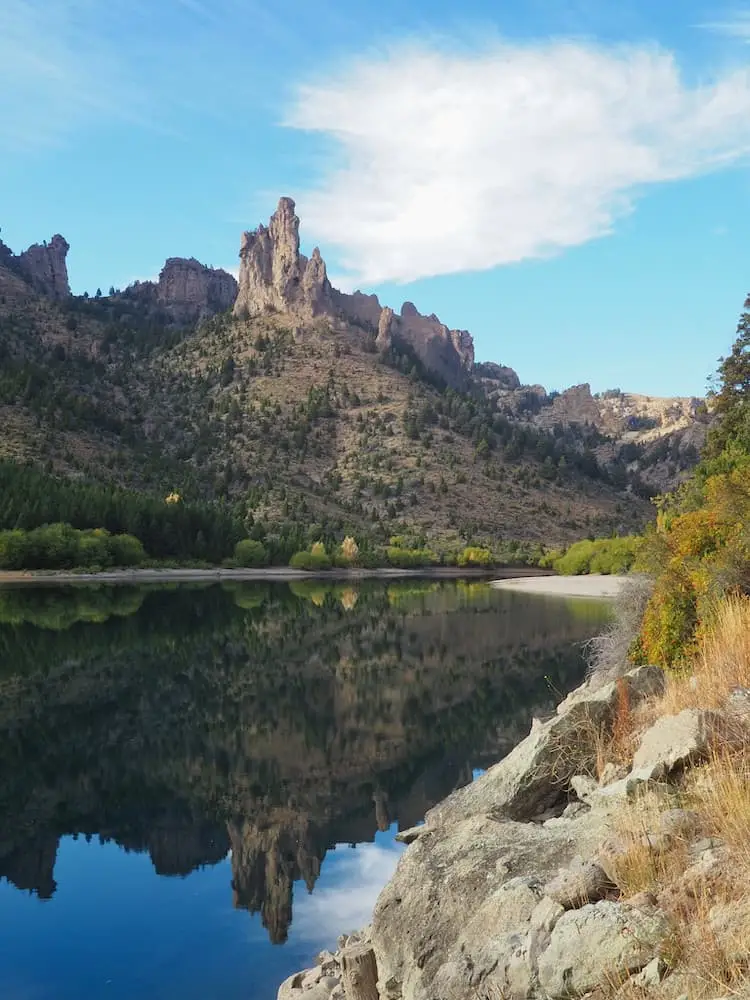 River with reflections in the water and craggy mountains above it