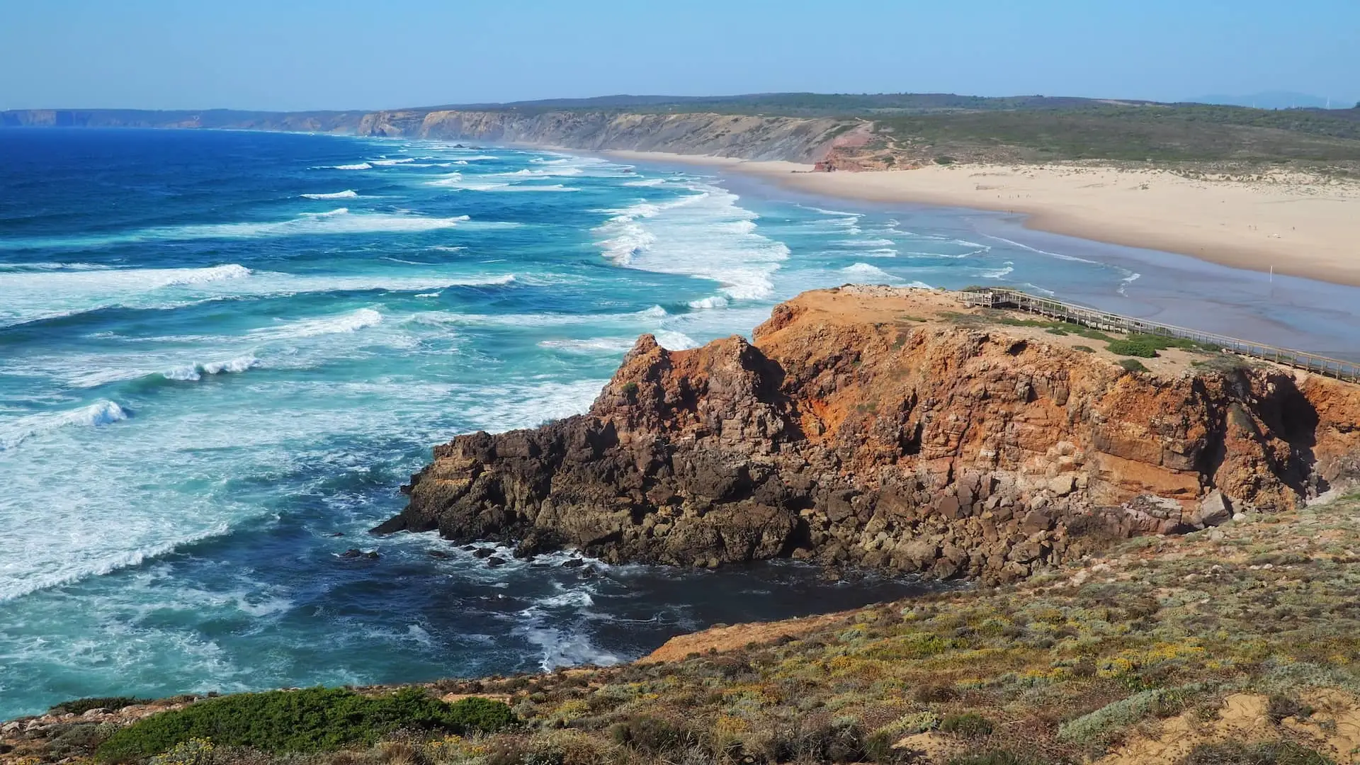 Praia da Bordeira, Carrapateira A rocky outcrop in front of large waves crashing on to a sandy beach