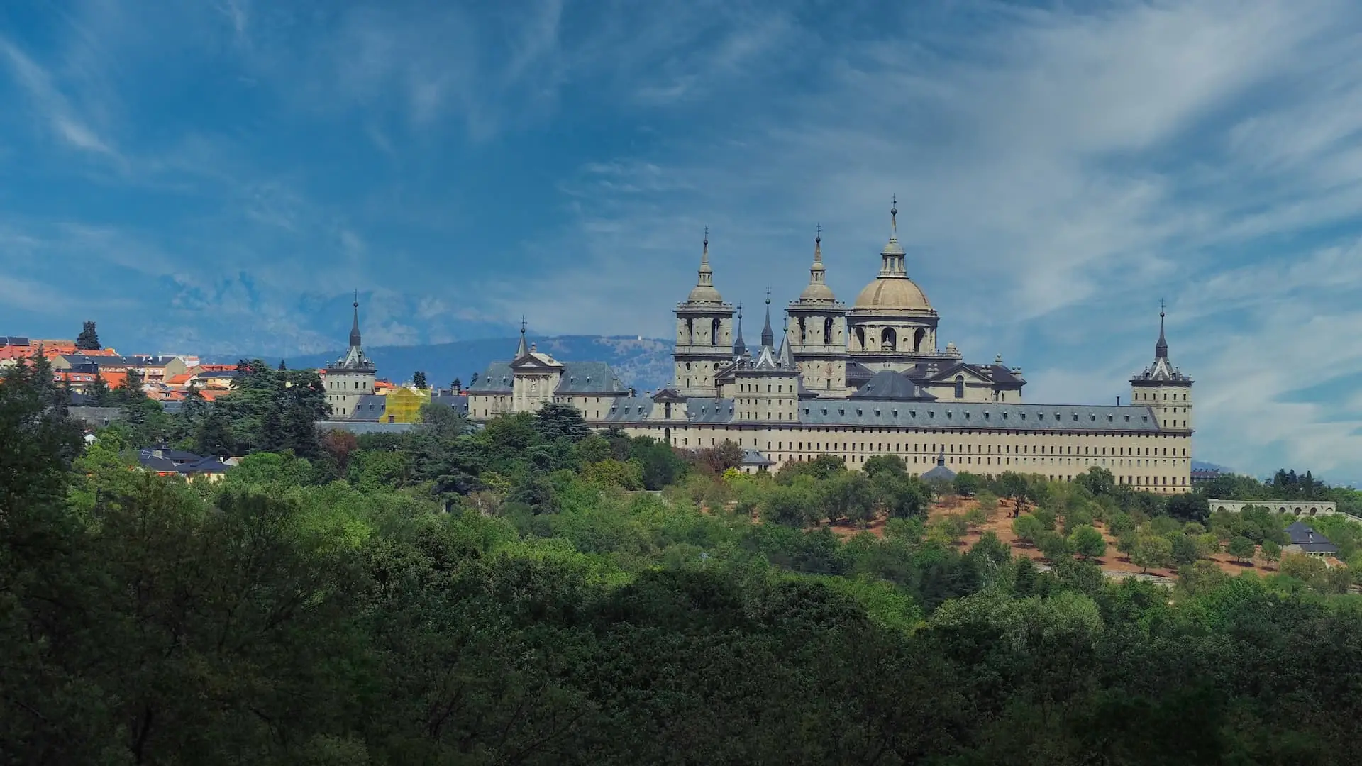 Day Trips from Madrid - El Escorial... A large domed building of grey granite stands out amidst green foliage