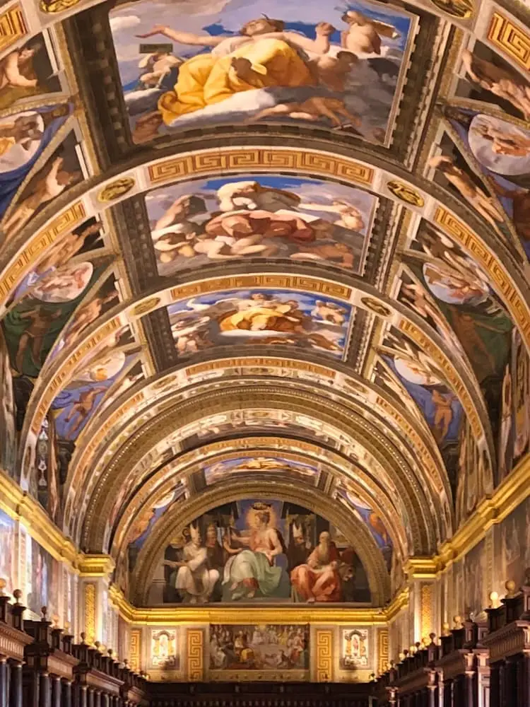 Day Trips from Madrid - El Escorial.. A curved and panelled ceiling with multiple religious frescoes