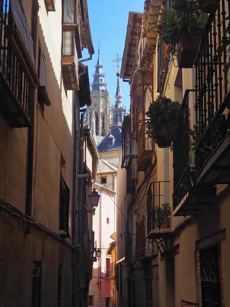 Day Trips from Madrid - Toledo... A narrow street with a cathedral spire in the background