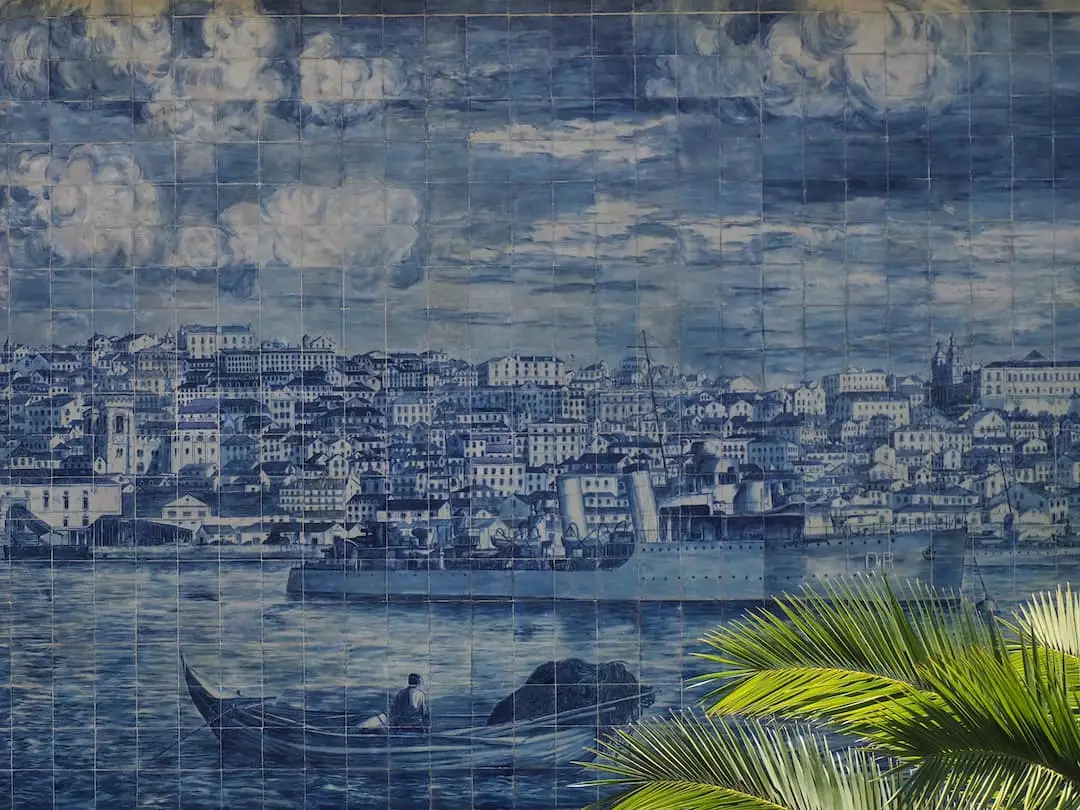 A vintage depiction of Lisbon on a collage of blue tiles with green leaves to the bottom right