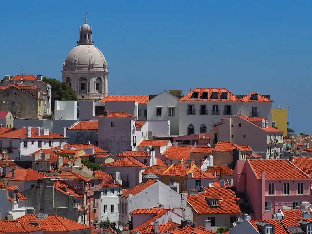 A view over red rooftops towards church with a domed roof