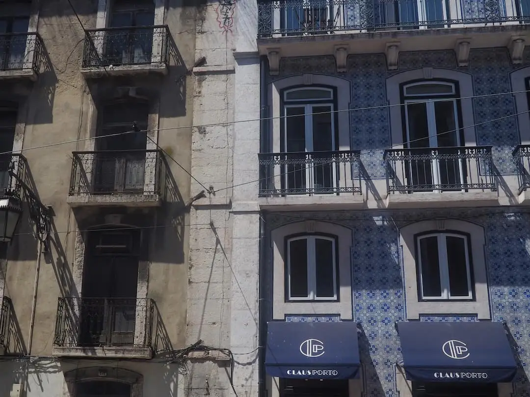 Two buildings side-by-side, one decorated with blue tiles and other plain