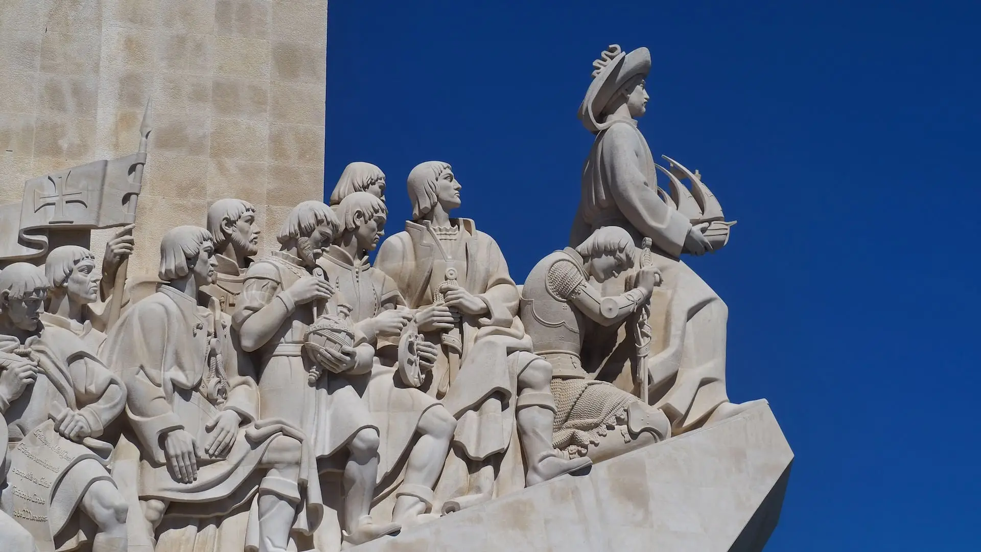 A collection of statues look out to sea from left to right
