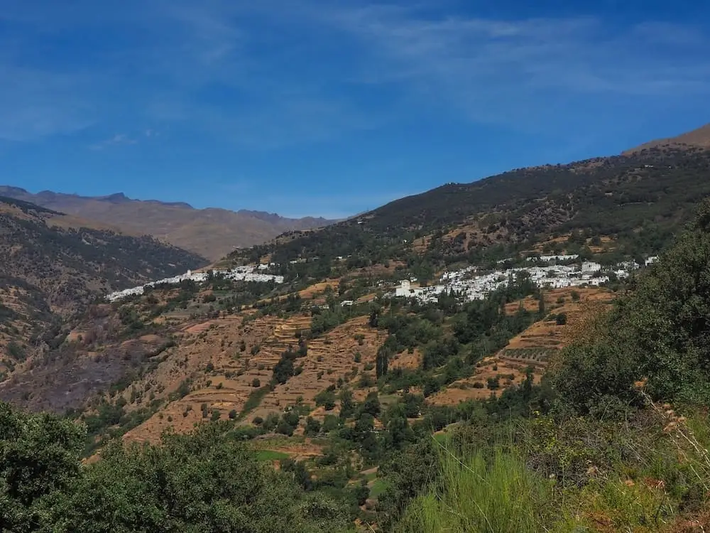 Two white villages on a green hillside