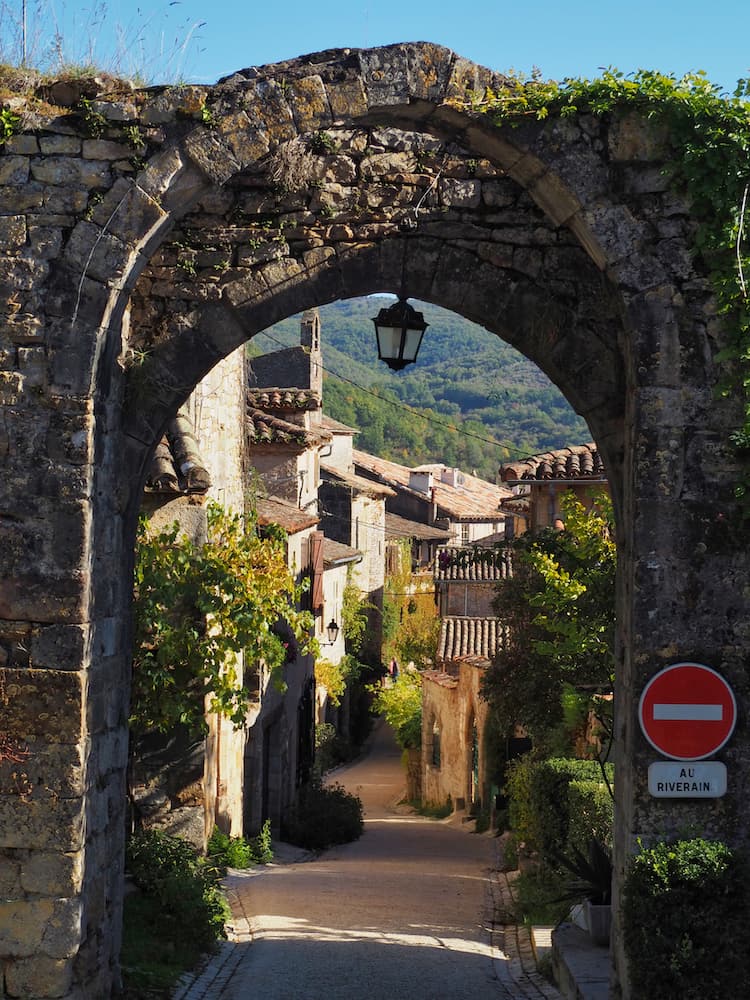 A stone arch leads through to a medieval street
