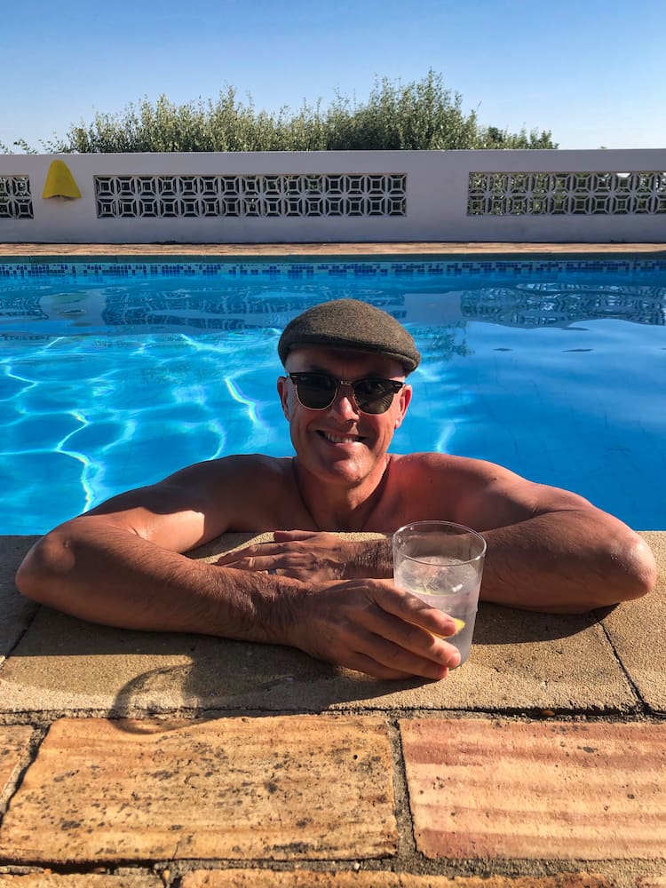 Ian with a drink inside a swimming pool