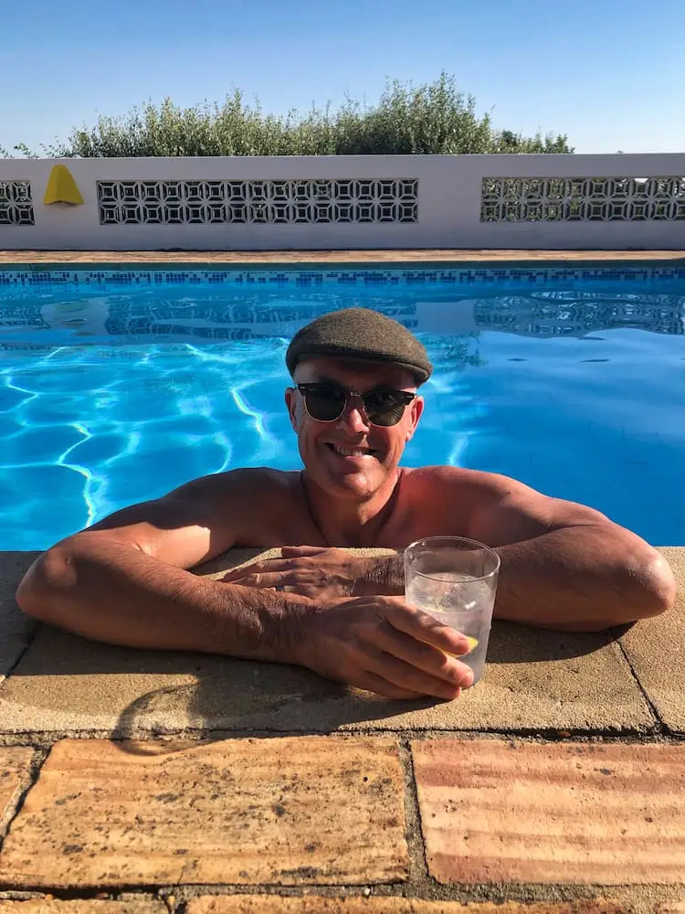 Ian with a drink inside a swimming pool