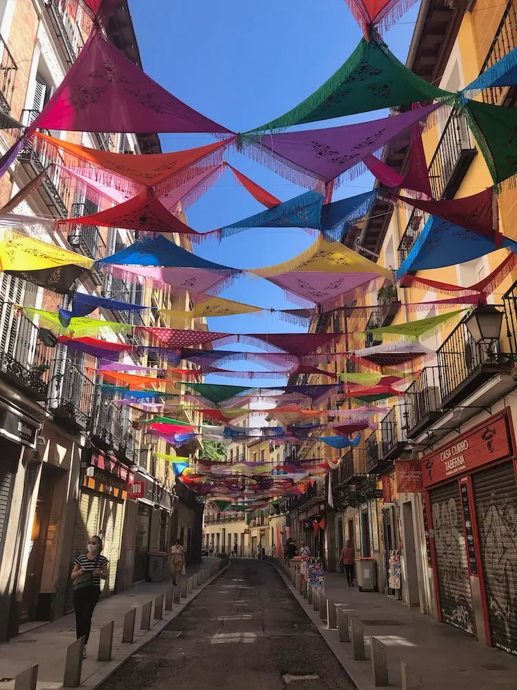A narrow, empty street with garlands stretched out between the buildings