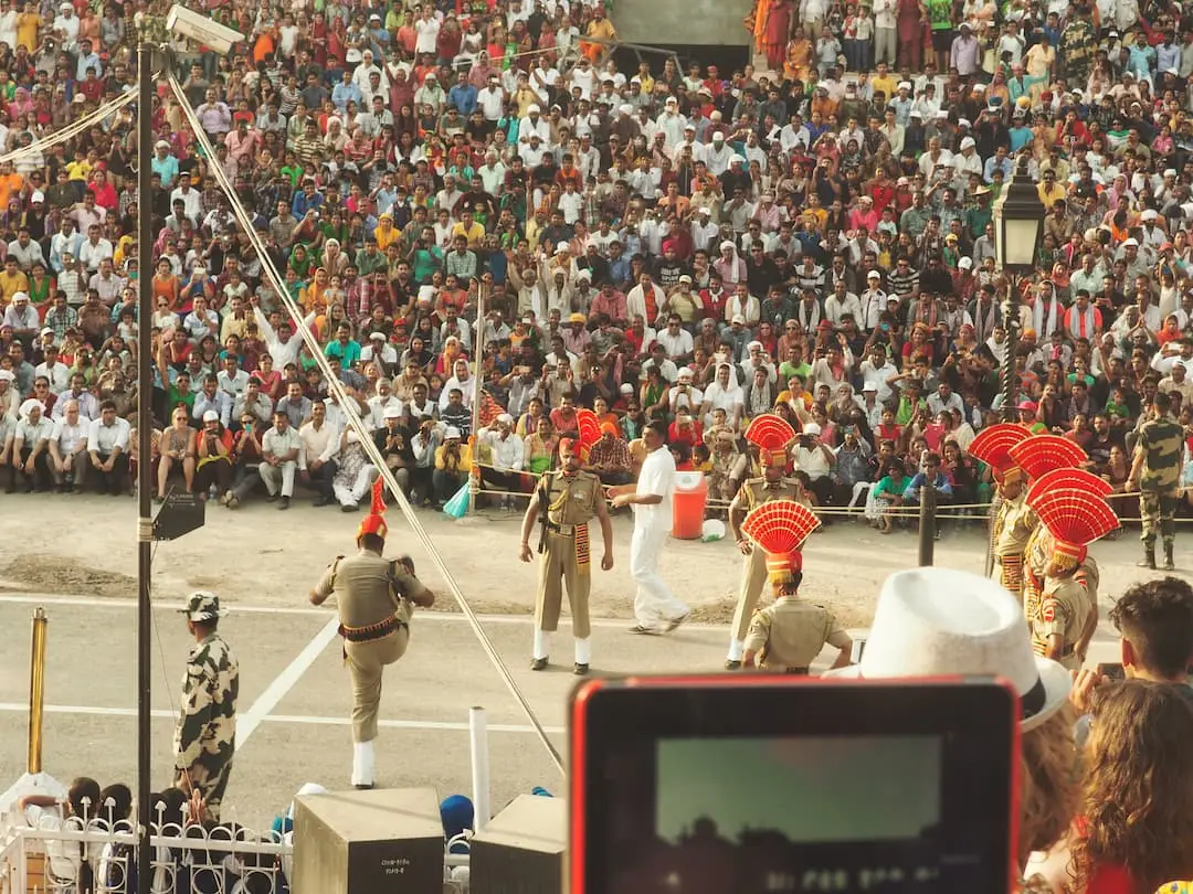 Soldiers stand in front of a seated crowd