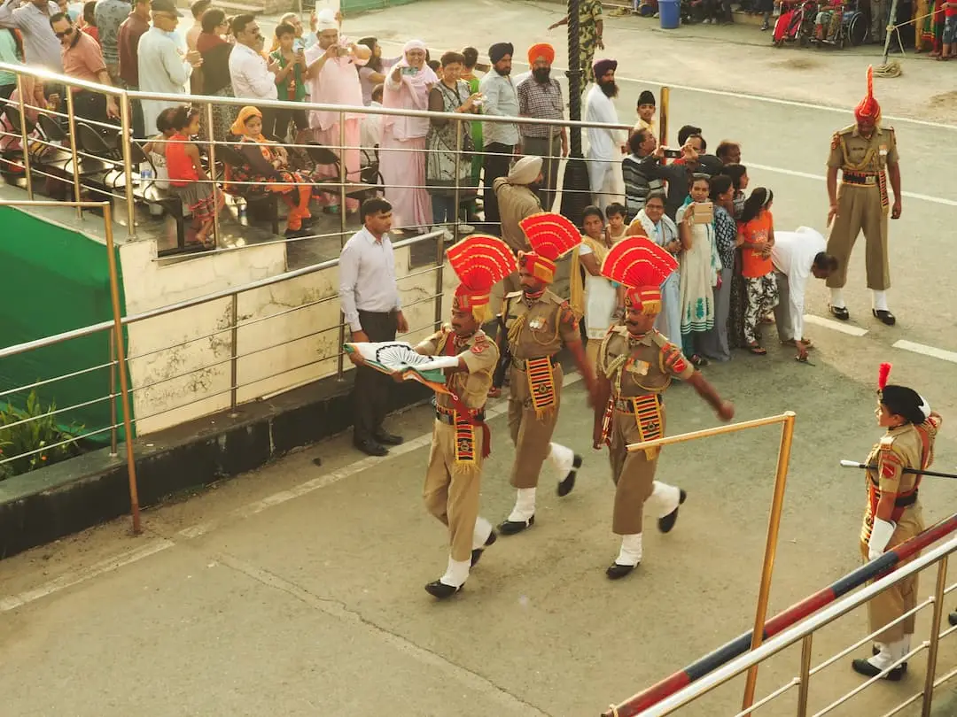 Three soldiers carry a flag away from the ceremony