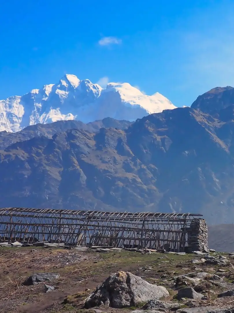 Farm building in the foreground and snow-capped mountain in the background