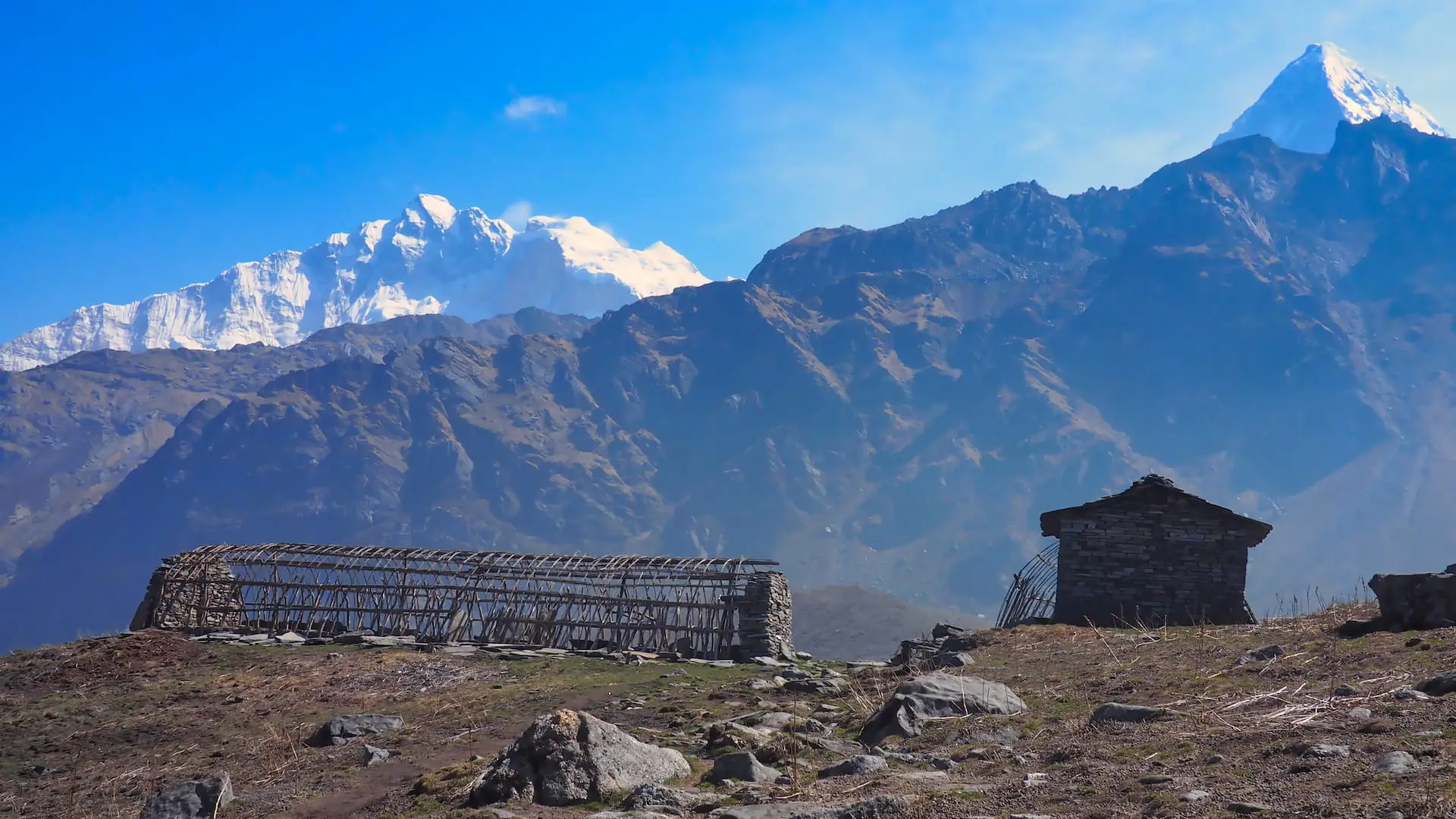 Farm buildings in the foreground and snow-capped mountains in the background