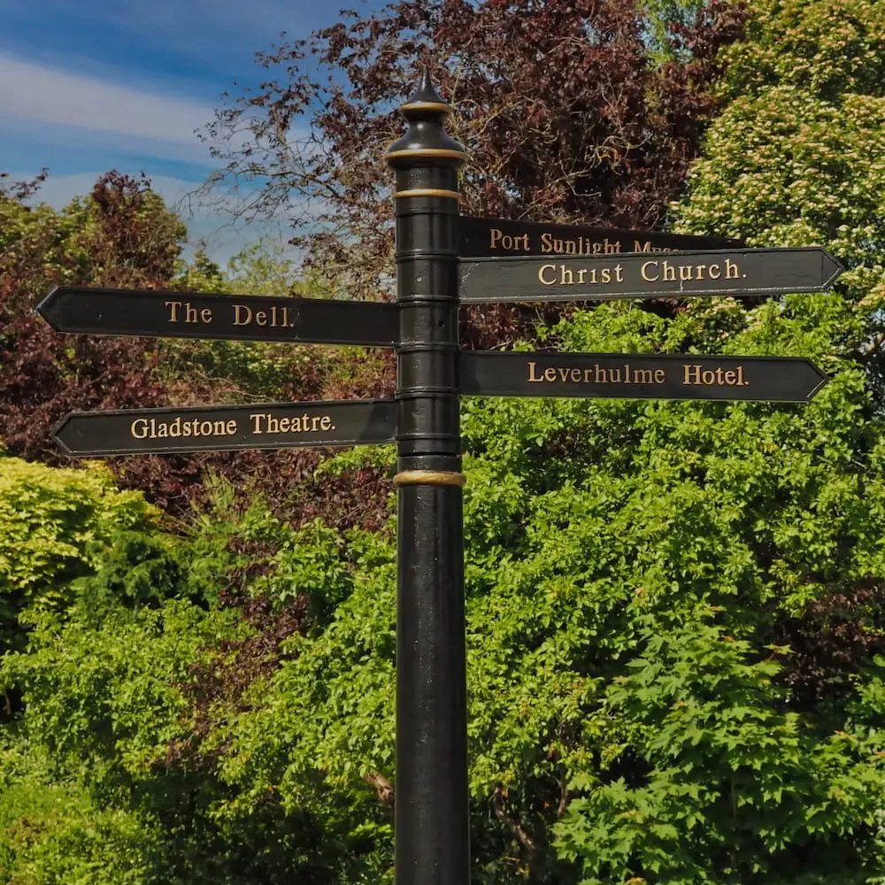 A black signpost with numerous directions