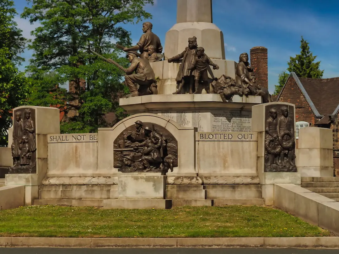 A stone memorial with bronze statues and plaques