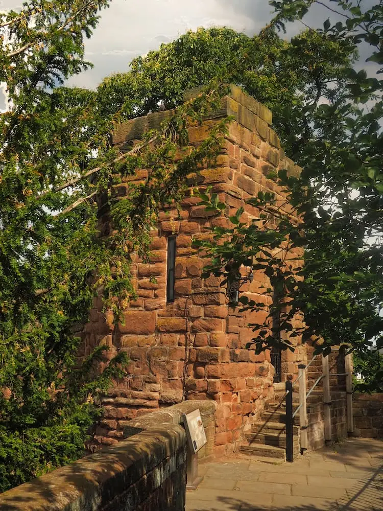 A sandstone tower stands amongst trees