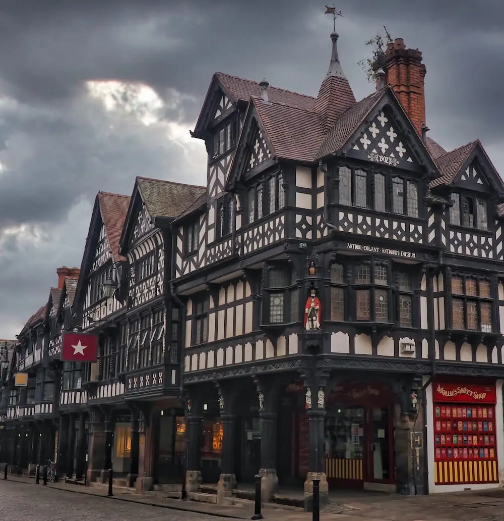 A black and white half-timbered building with paved archway on the ground floor