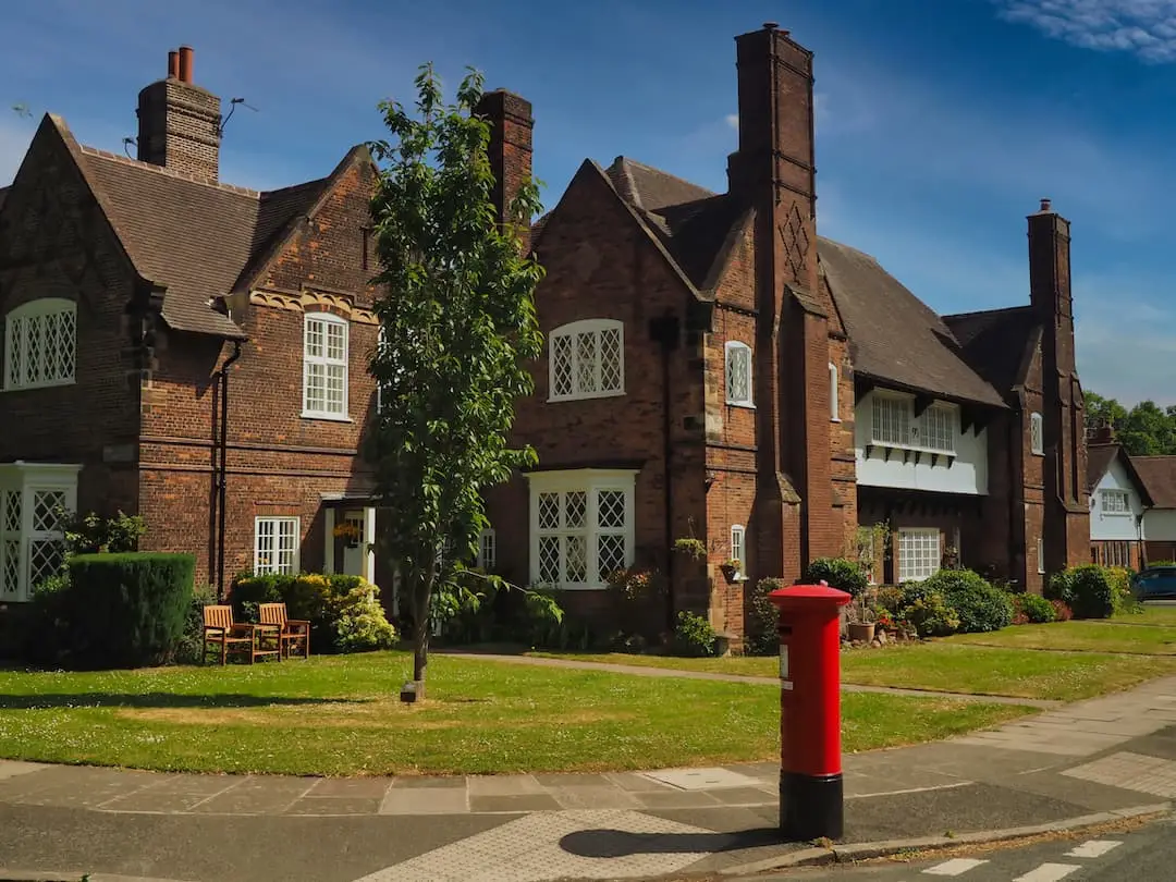 A red post box in front of a row of houses