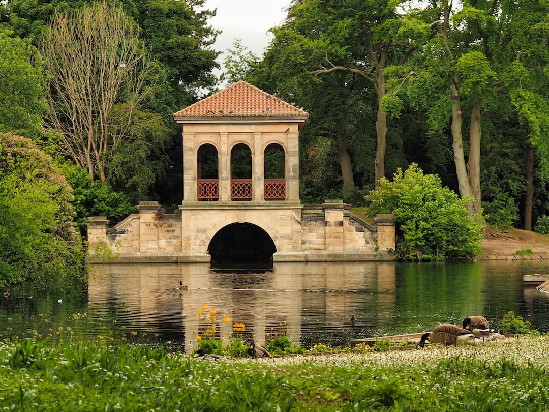 A bridge with a tower and three arches straddles a lake