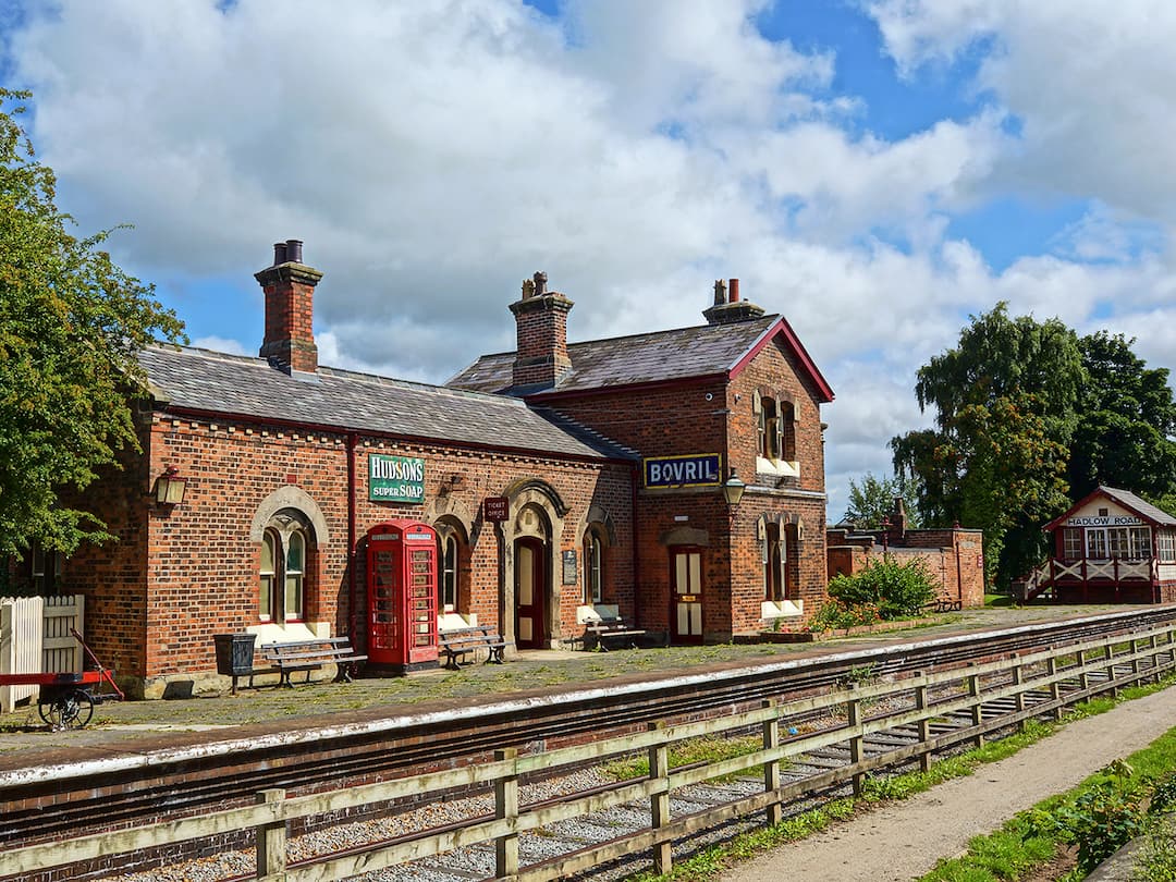 An old train station with a red telephone box on the platform