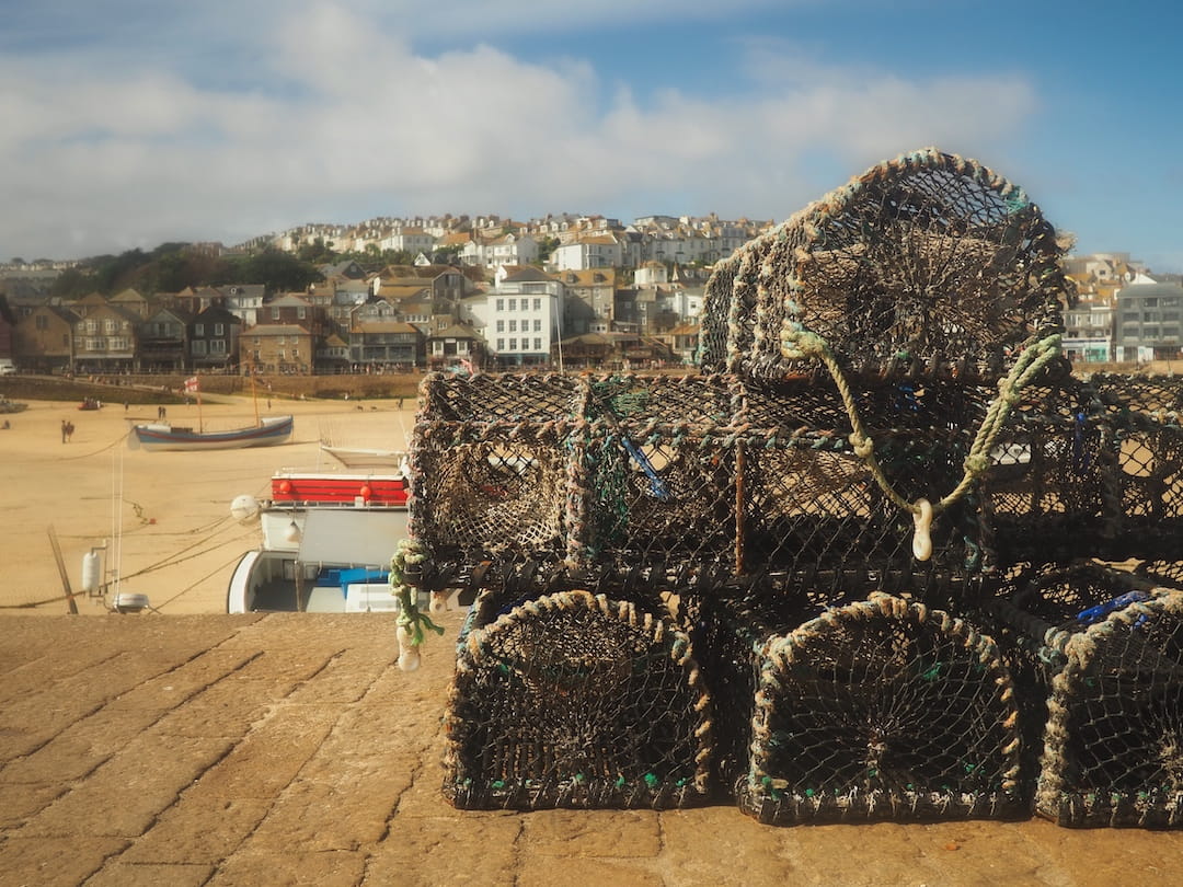 Lobster crates in the foreground a beach and buildings in the background 