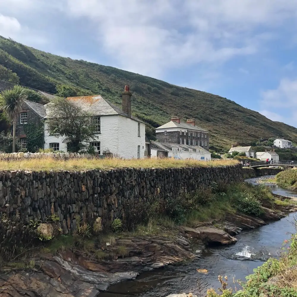 Boscastle - view looking back from the harbour A river runs beside a wall, with stone buildings running alongside