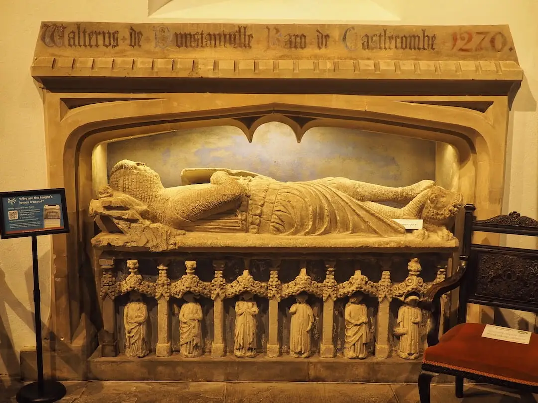 A stone tomb of a knight with legs crossed