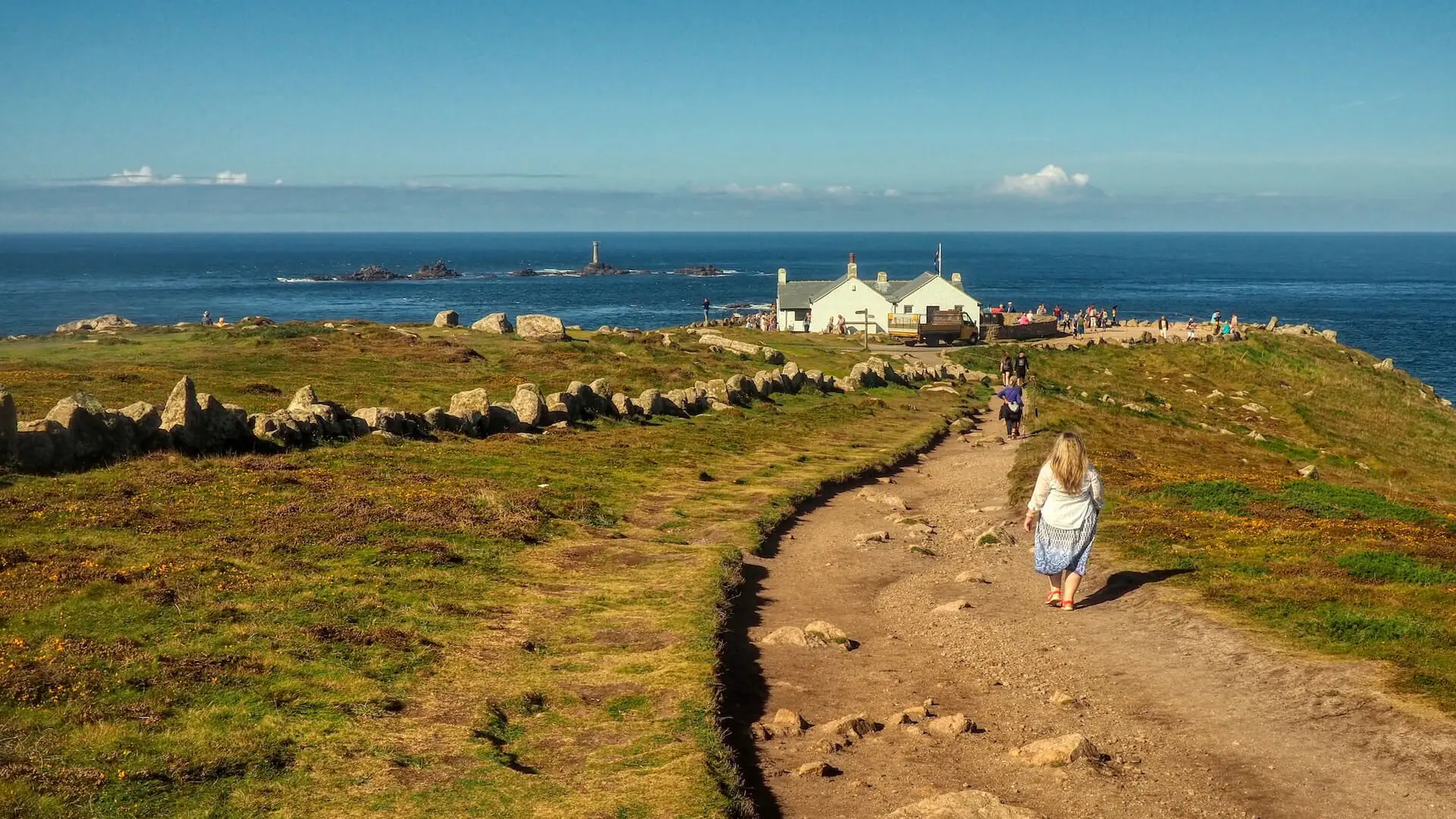 A woman stands on a rock and turns to the camera