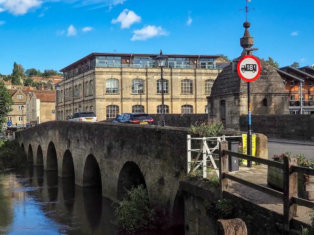 A stone bridge with arches crosses a river