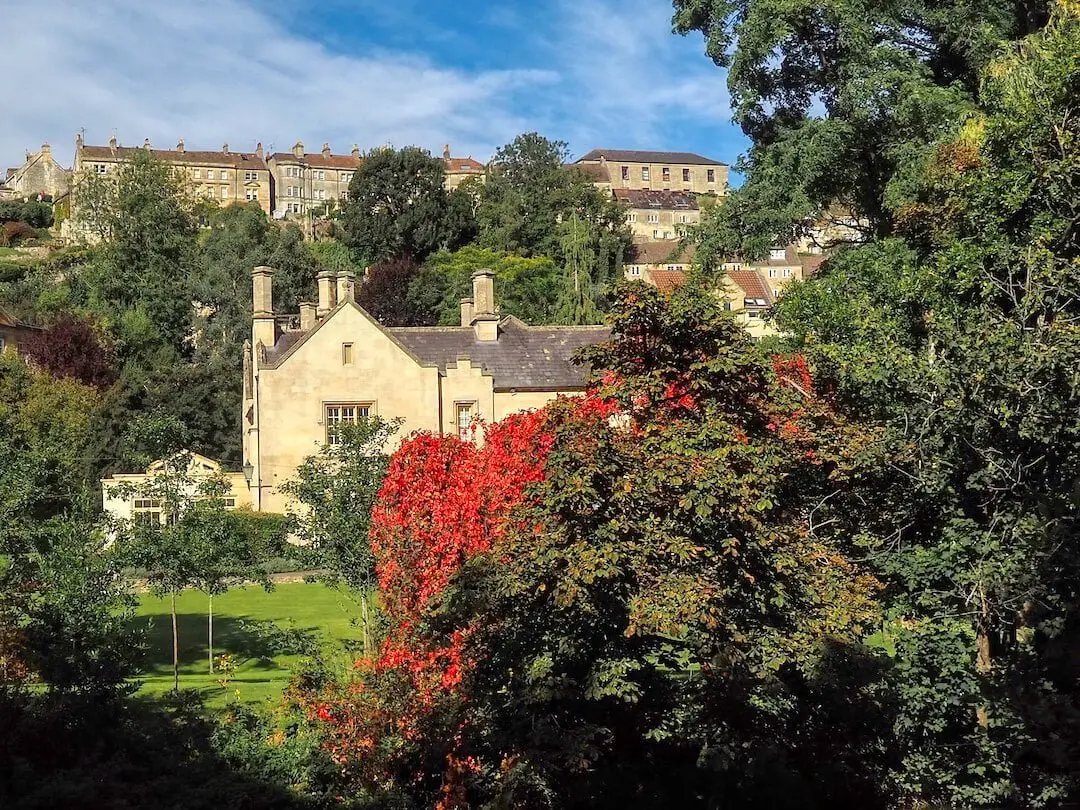 Terraced hillside housing in the background, green foliage and red flowers in the foreground