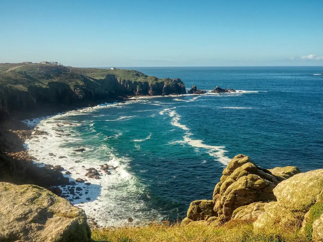 The remains of a shipwreck lies on a beach between two cliffs